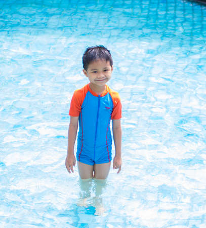 Portrait of smiling Asian boy at public swimming poolの写真素材