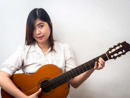 Beautiful Young Asian - Chinese Woman Playing Guitarの写真素材