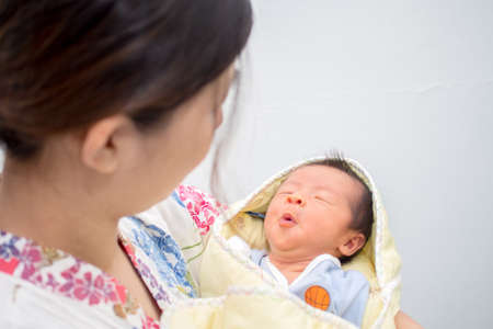 Whistling Baby Carried by Momの写真素材