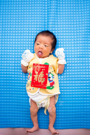 Baby Lying with Chinese Red Envelopeの写真素材