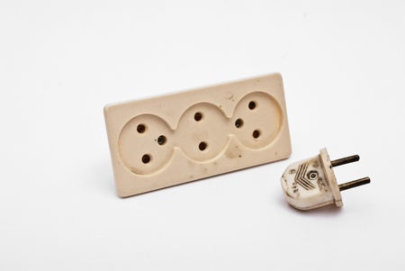 Old wall-plug and fork on white backgroundの写真素材