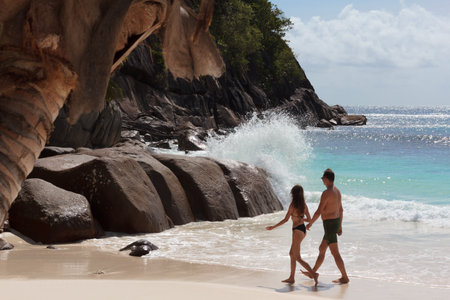 Couple walking on the magnificent Petit Anse beach, Mahe, Seychellesの写真素材