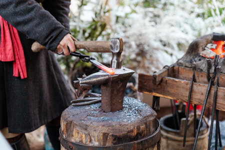 Blacksmith making horseshoe on an anvil in winterの写真素材