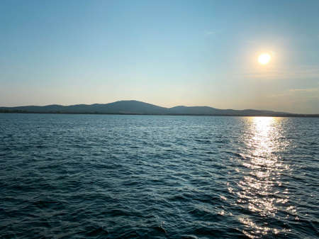 Great seascape with the land at the horizon at sunsetの写真素材