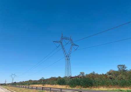 High voltage power line utility pillars. Transmission towers overheadの写真素材
