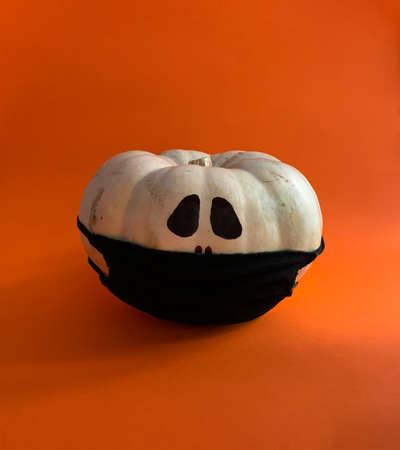 Covid-19 pumpkin in Halloween wearing black protective maskの写真素材