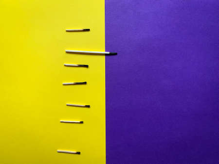 Abstract concept with burnt matches on a half yellow and half purple background layoutの写真素材