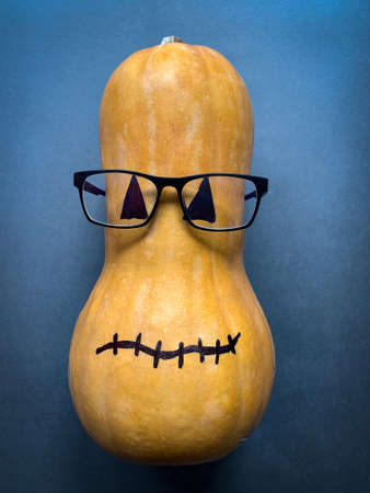 Funny pumpkin with glasses on dark backgroundの写真素材