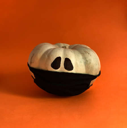 Halloween jack o lantern white pumpkin wearing black mask against virus infection of Coronavirus or COVID-19の写真素材