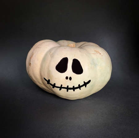 Halloween pumpkin with skull face painting isolated on black backgroundの写真素材