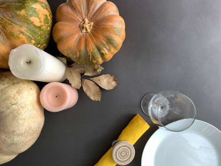Thanksgiving dinner autumn background. Top view with plate, wine glass, napkin, pumpkins and candles...