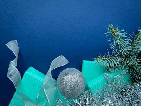 Merry Christmas and Happy Holidays top view greeting card, frame, banner. Christmas composition with blue gifts silver decorations on blue background.の写真素材