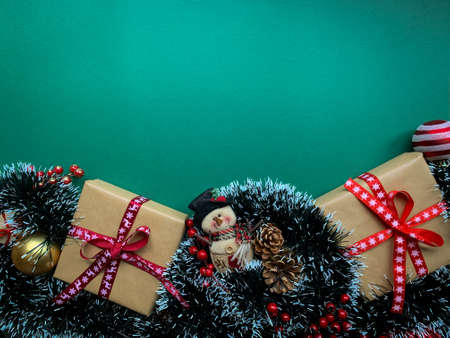 Green Christmas background frame with copy space. Cute snow man toy, Christmas gifts and decorations.の写真素材