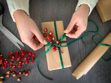 Top view woman's hands tying the ribbon on the gift. Handcraft presentの写真素材