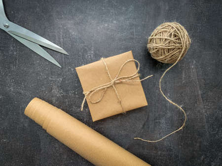 Rustic christmas gift wrapping workspace with craft paper, twine and scissors.の写真素材