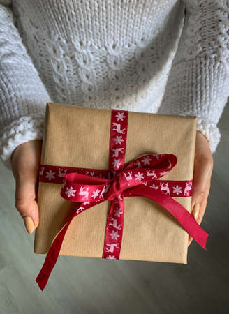 Giving a Christmas gift. Happy holiday, gift box close-up. Christmas present in hands.の写真素材