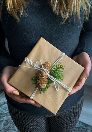 Woman with sweater hold handcrafted gift box. Christmas presents and New Year.の写真素材