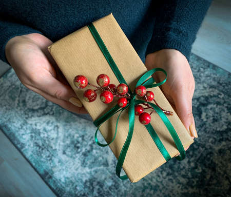 The hand holds a gift box with a green ribbon.の写真素材