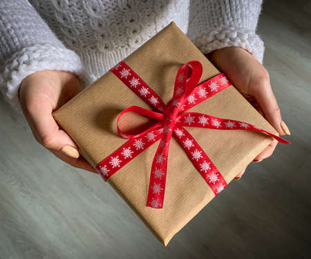 Female hands holding nicely wrapped Christmas presentの写真素材