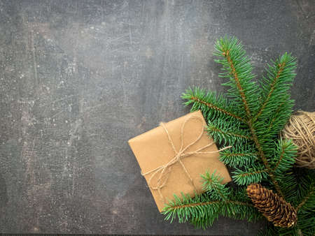 Christmas frame of spruce, pine cone, twine and present on wooden background. Copy space. Winter holidays, New Year.の写真素材