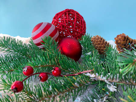 New Year composition. The branches of spruce with berries and pine cone. Christmas balls on the background of snow.の写真素材