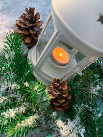 Christmas lantern on snow With pine branch illuminated by sunlight. Happy New Year card. Holiday concept.の写真素材