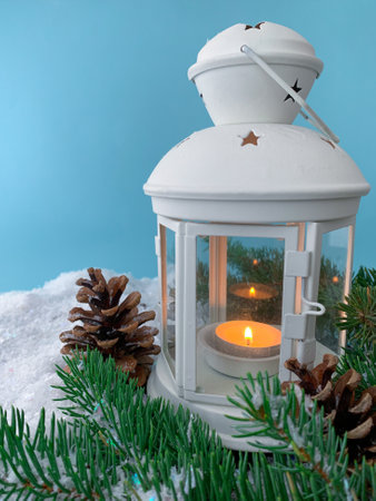 Winter background with candle lamp. Christmas lantern and pine tree on snow.の写真素材
