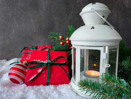 Christmas decorated glowing lantern and presents on snow with copy space.の写真素材