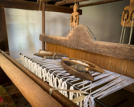 Close up wooden weaving and shuttle loom over white yarn on old hand loom.の写真素材
