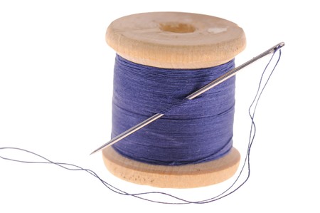 spool of thread and sewing needle, isolated on white background