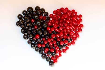 Heart shape assorted berry fruits on white background. Black-blue and red food. Mixed berries with copy space for text. Various fresh summer berries.の写真素材