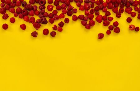 raspberries on yellow background. Colorful diet and healthy food concept. Background of raspberries. Top view. Copy spaceの写真素材