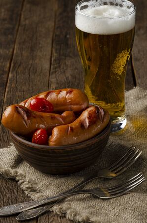 grilled sausages on the clay cup on the woodenの写真素材