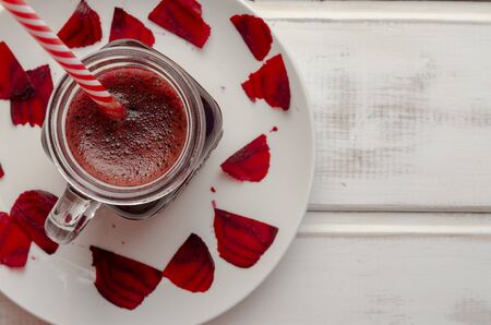 Healthy beetroot smoothie in a jar on white woodenの写真素材