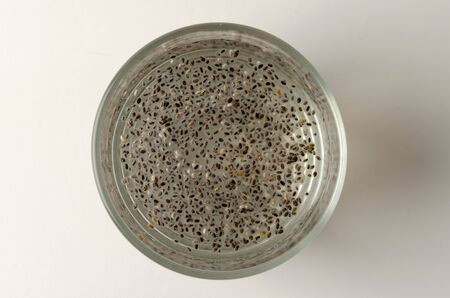 Glass of chia seeds soaking in water isolated on white backgroundの写真素材
