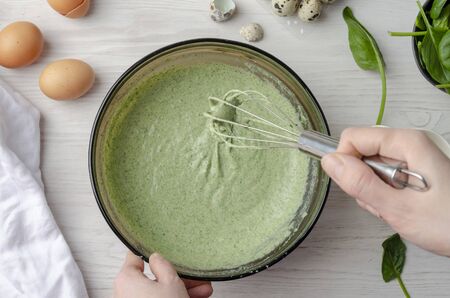 Baking pancake with spinach on white table