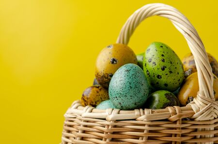 Easter eggs in basket on color wooden background copyの写真素材