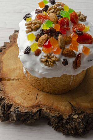 Kulich Easter cake with white glaze on white wooden
