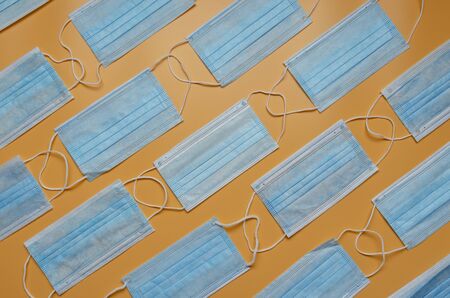 Many medical masks on the colored background to cover the mouth and nose for protection from virus. Epidemic concept. pattern.の写真素材