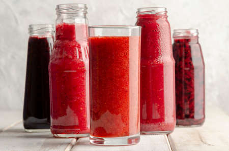 Glass jars with different smoothies with fresh berriesの写真素材