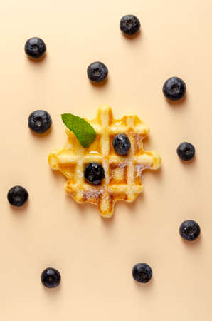 Sweet tasty waffles and berries on colored backgroundの写真素材