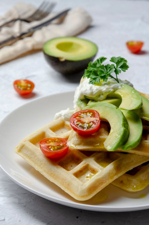 Vegan waffles with avocado with yogurt and cherry tomatoの写真素材