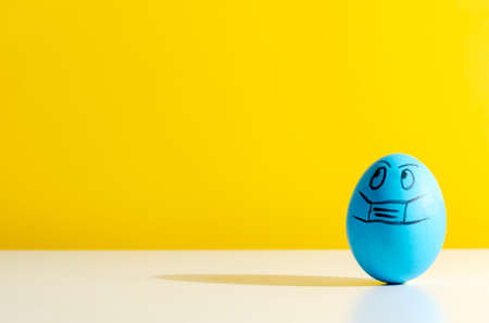Easter eggs in a protective medicine mask. Easter quarantine concept.の写真素材