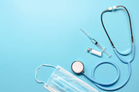 Ampoule with vaccine , syringe and stethoscope on blue background. Flat lay with copy spaceの写真素材