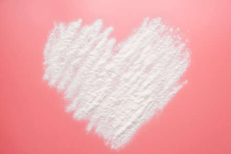 Collagen powder on pink background. Heart shaped.の写真素材