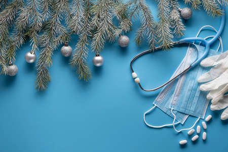 Medical Christmas decoration with stethoscope and masks on blue background. Medicine concept. Copy space for textの写真素材