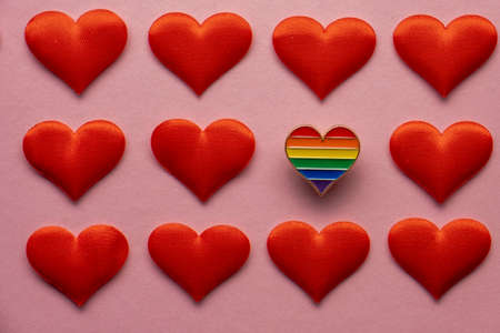 Heart shaped badge with Lgbt gay rainbow flag on pink background. LGBT Valentines day concept.の写真素材