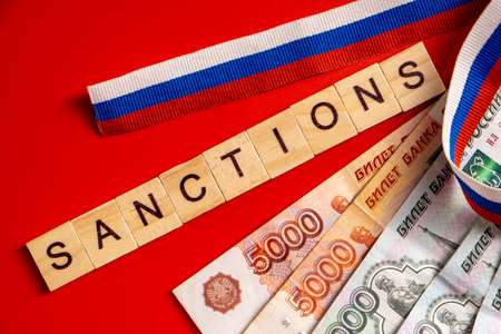 Russian ruble banknotes issued by the Bank of Russia on red background with Russian flag ribbon....