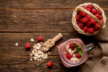 Smoothie with raspberry, oatmeal and mint in a jar on rustic wooden background.の写真素材