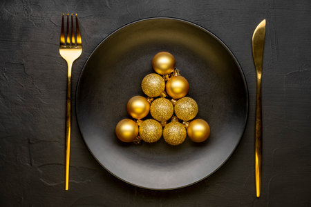 Golden Christmas table. Plate with Christmas decorations on black background. Happy new year.の写真素材